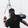 workout hairstyle: man with long locs tied into a ponytail, doing kickboxing