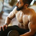 workout hairstyle: man lifting weights, with an undercut and ponytail