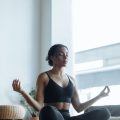 woman doing a home meditation with her hair tied into a low bun hairstyle