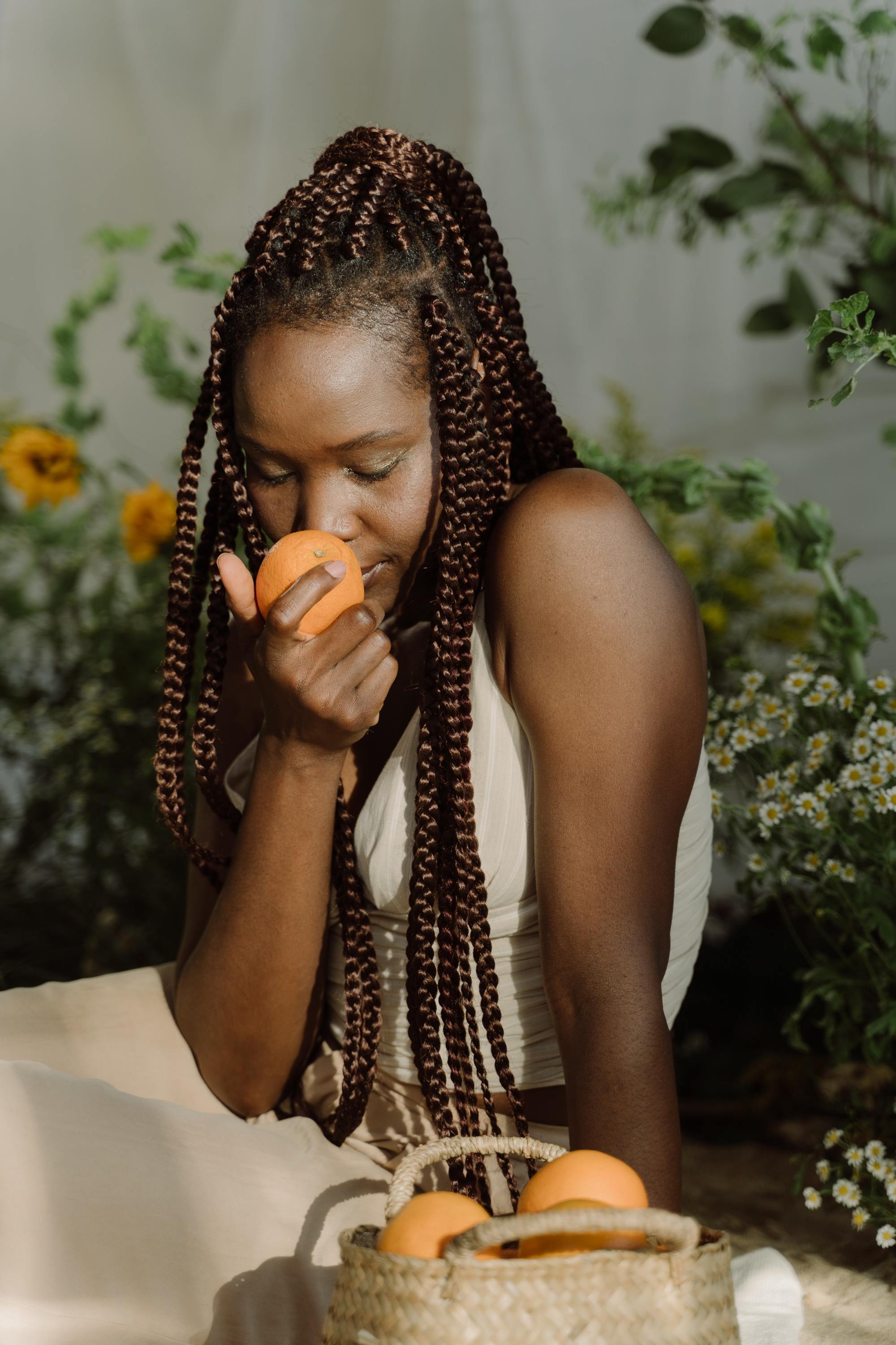 woman with long brown braids tied into a half-up ponytail