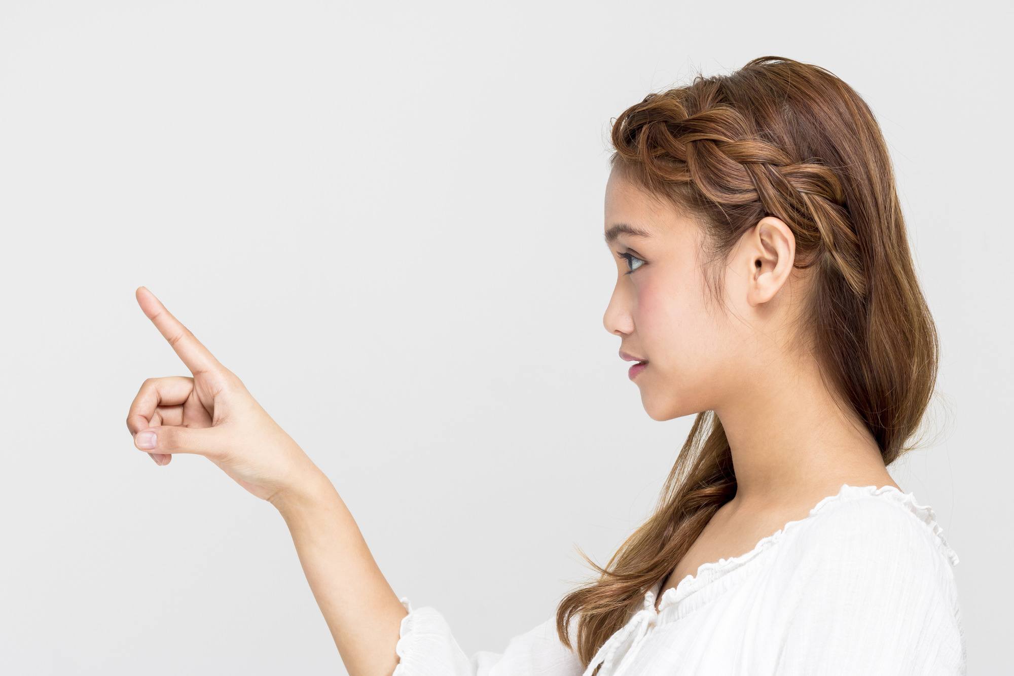 side profile of a woman with brown hair and a single dutch plait on one side of her head