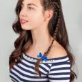 half braided hairstyles: woman with wavy brown hair and an accent braid on one side of her head