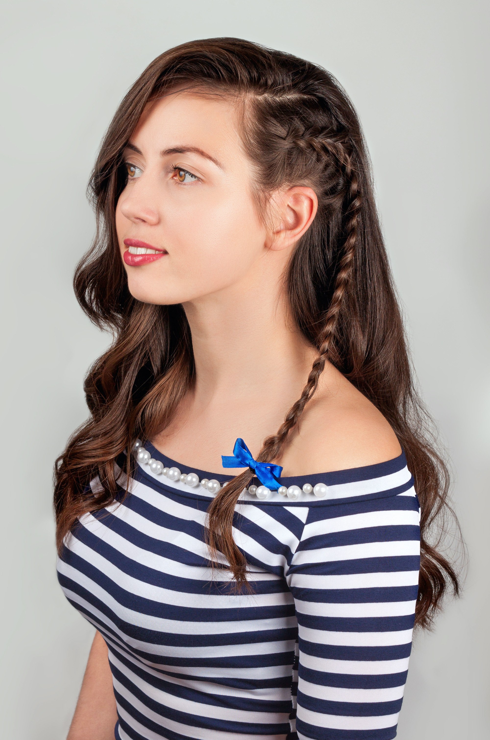 woman with wavy brown hair and an accent braid on one side of her head