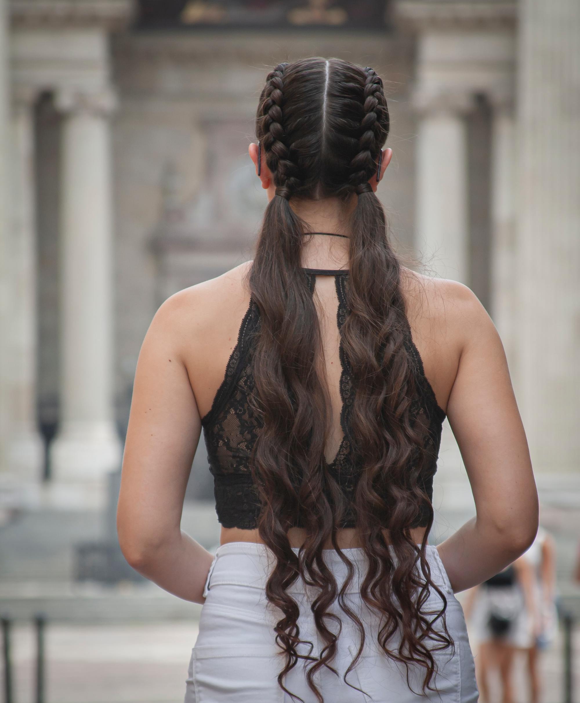 woman with double braided ponytails and long wavy brown hair