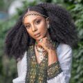 half braided hairstyles: woman with Fulani braids and her long, loose natural hair