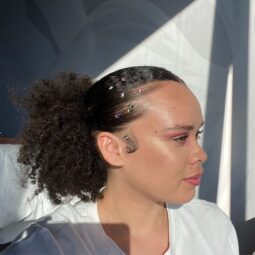 woman with a slicked back ponytail and rhinestones on the baby hairs