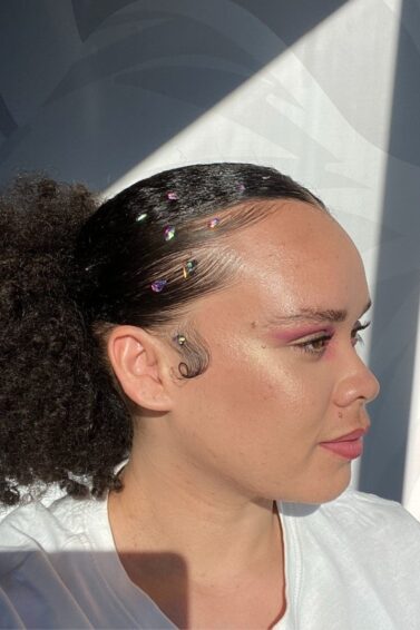 woman with a slicked back ponytail and rhinestones on the baby hairs