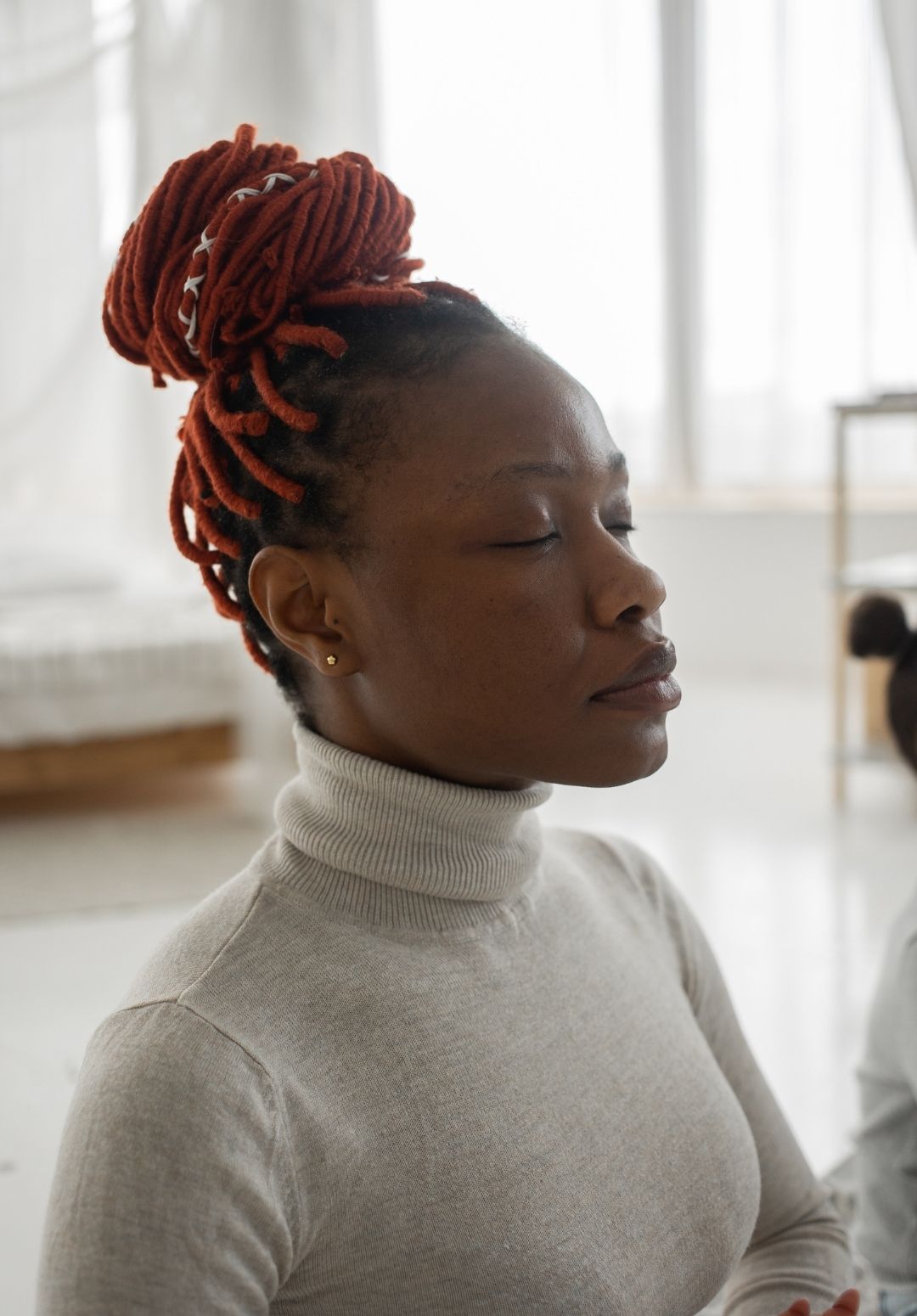 woman with reddish-orange braids tied up into a bun