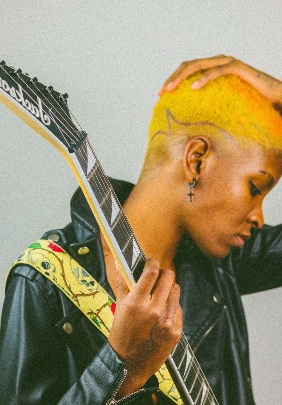 close-up image of a woman with very short sunflower-yellow natural hair with a shaved-in design