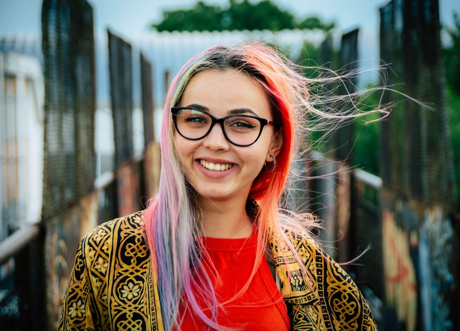 Woman with lavender, yellow and orange hair with dark roots
