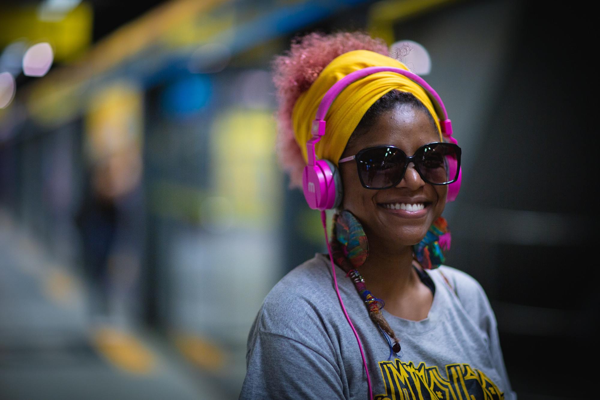 winter hairstyles: woman with pink natural hair wearing a bright yellow head scarf
