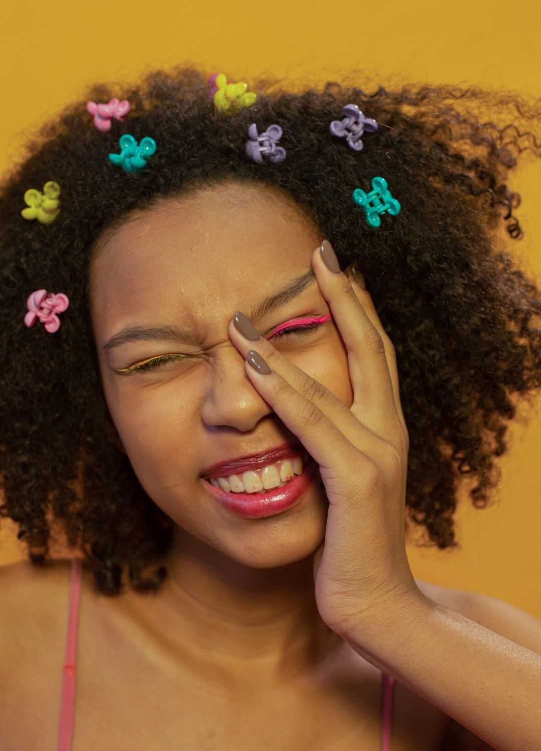 woman with natural curly hair with brightly colour butterfly clip-on accessories scattered on her hair