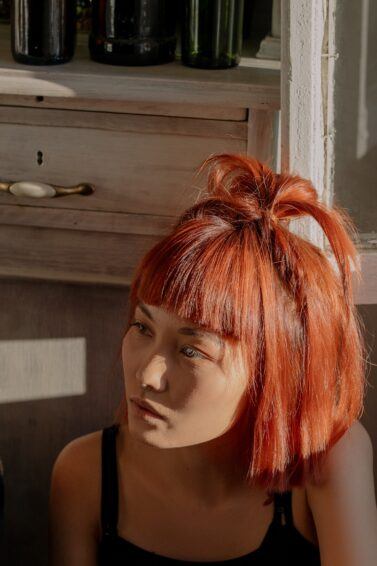 Kpop inspired hairstyle: woman with short bob hairstyle; hair dyed vibrant orange