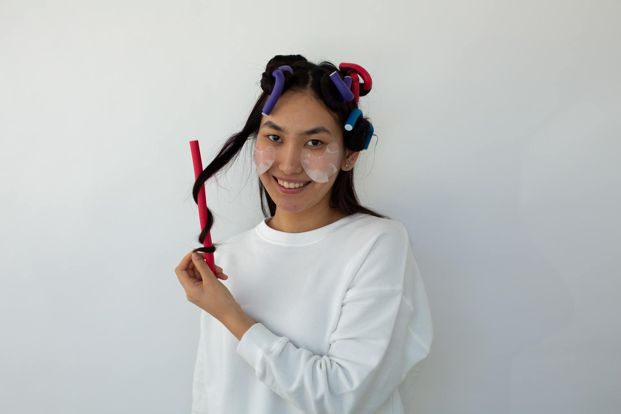 woman with flexi rods in her hair, rolling hair around one of the rods