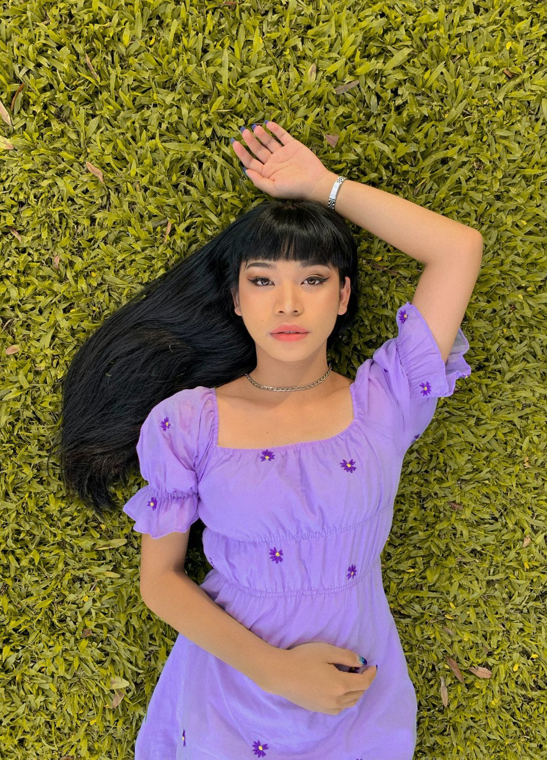 woman with long sleek black hair with a full, straight-cut fringe