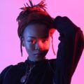 woman with locs tied up into a ponytail hairstyle with a burgundy headband