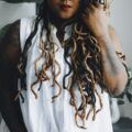 woman with long locs that are half dyed black, and half are bleached blonde