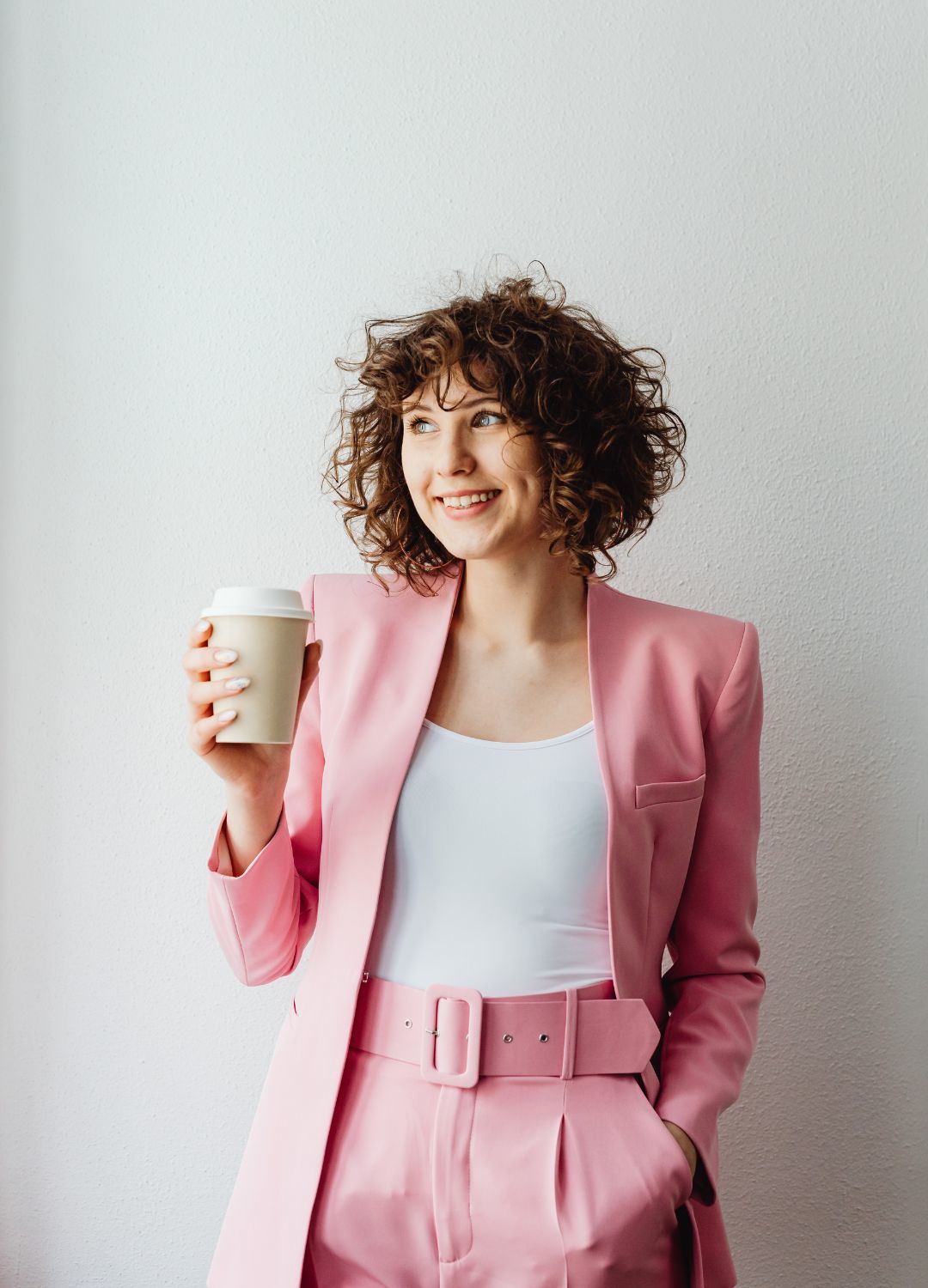 fine curly hair: woman in a pink suit with chin-length curly brown hair