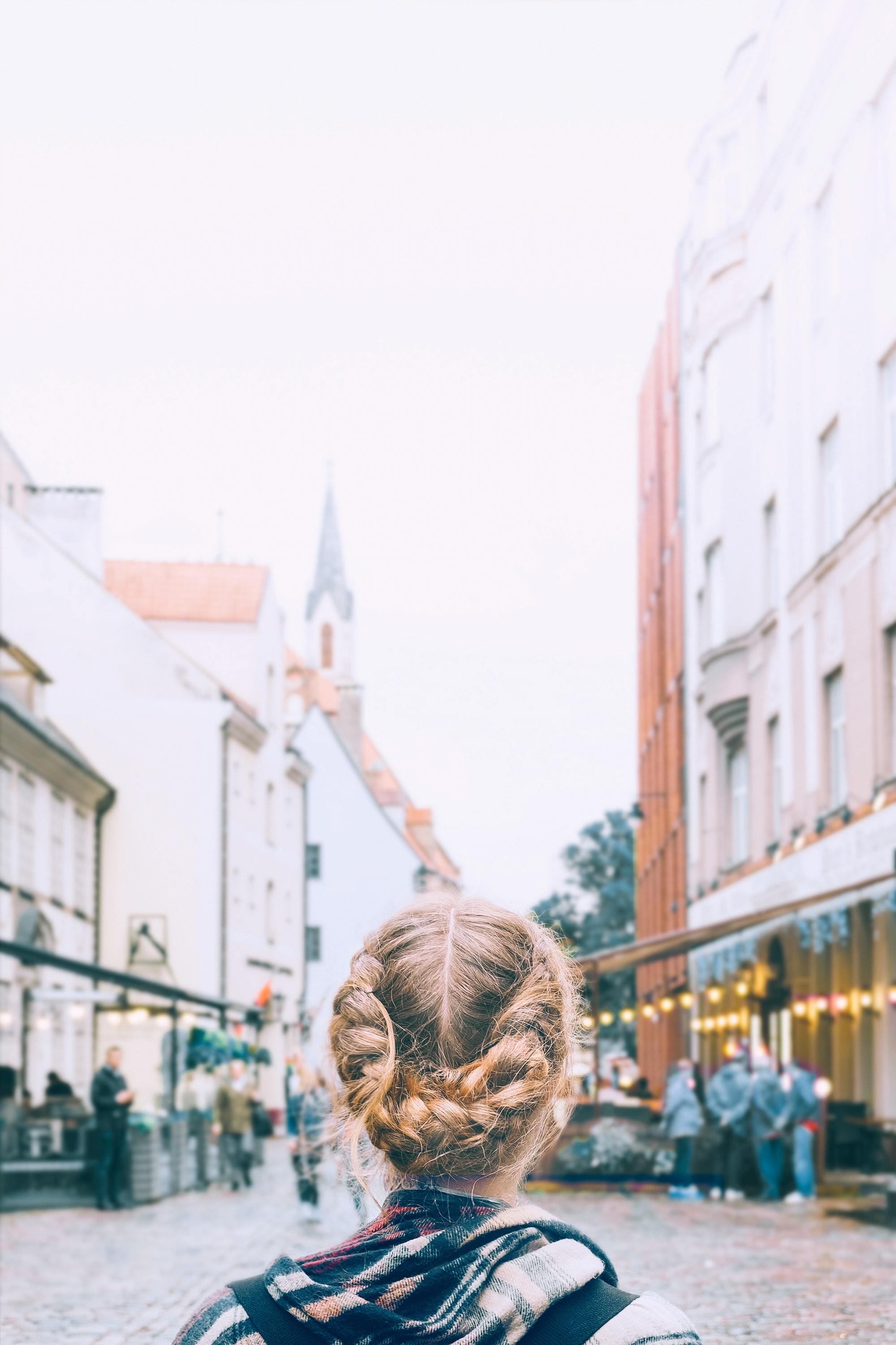 woman with blonde hair tied into two plaits and wrapped around the back of her head to for a milkmaid plait