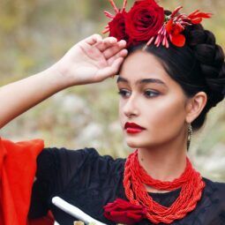 Mujer con peinado mexicano inspirado en Frida Kahlo, con flores y corona de trenzas