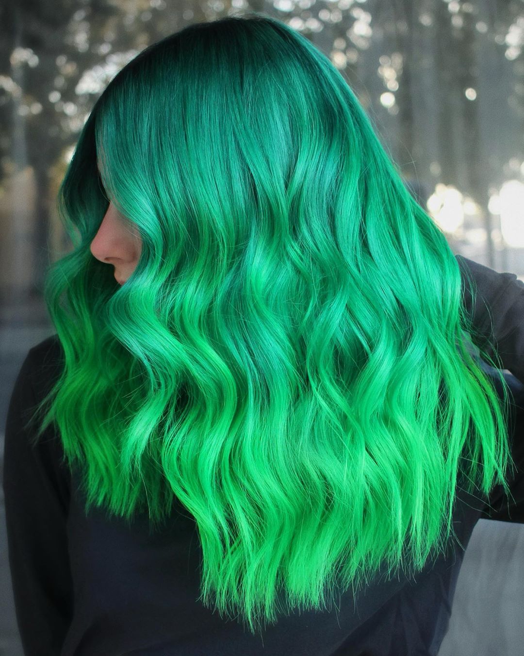 Mujer con cabello verde en degradado de turquesa a neón