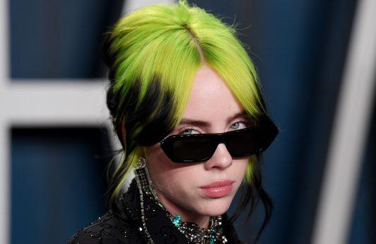Billie Elish con cabello verde neón y negro en un chongo