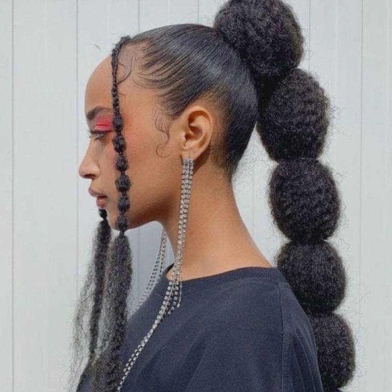 Mujer con cabello afro y un peinado de coleta elegante