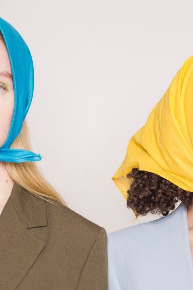 Dos mujeres, una rubia y una morena, con pañoletas coloridas en el cabello