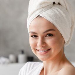 Mujer en el baño con el cabello envuelto en una toalla