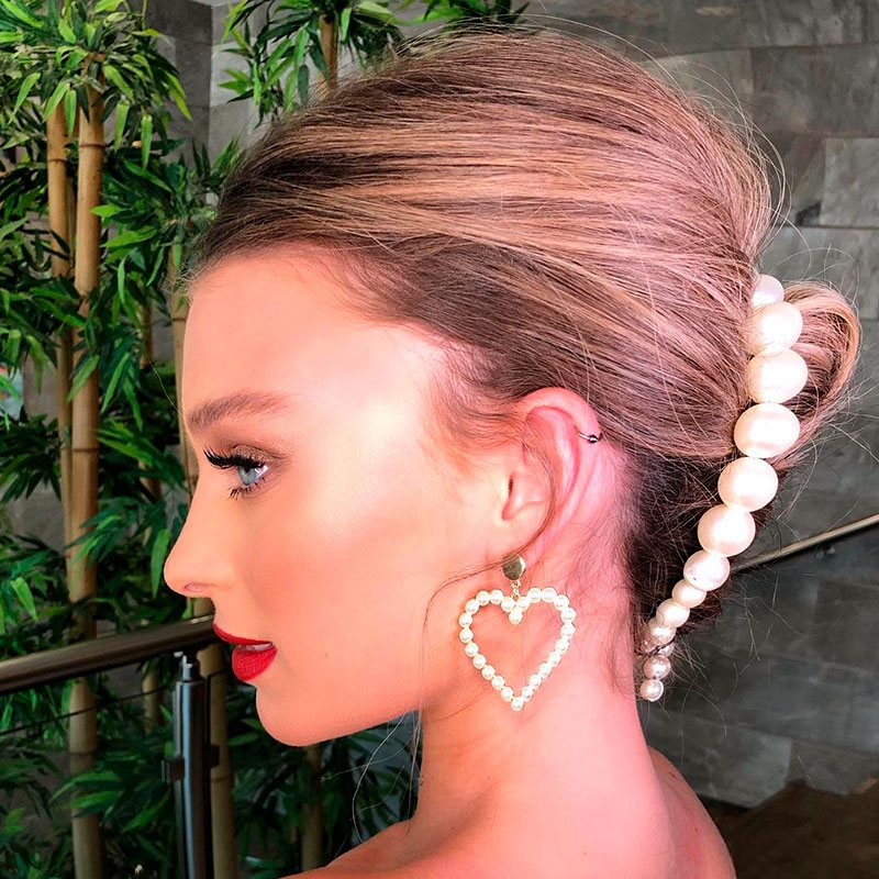 Mujer con peinado para boda con cabello corto recogido decorado con un broche de perlas