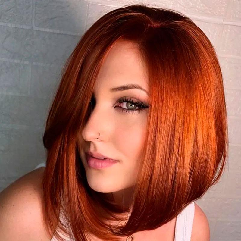 Mujer con corte de pelo bob escalonado, cabello rojo anaranjado lacio