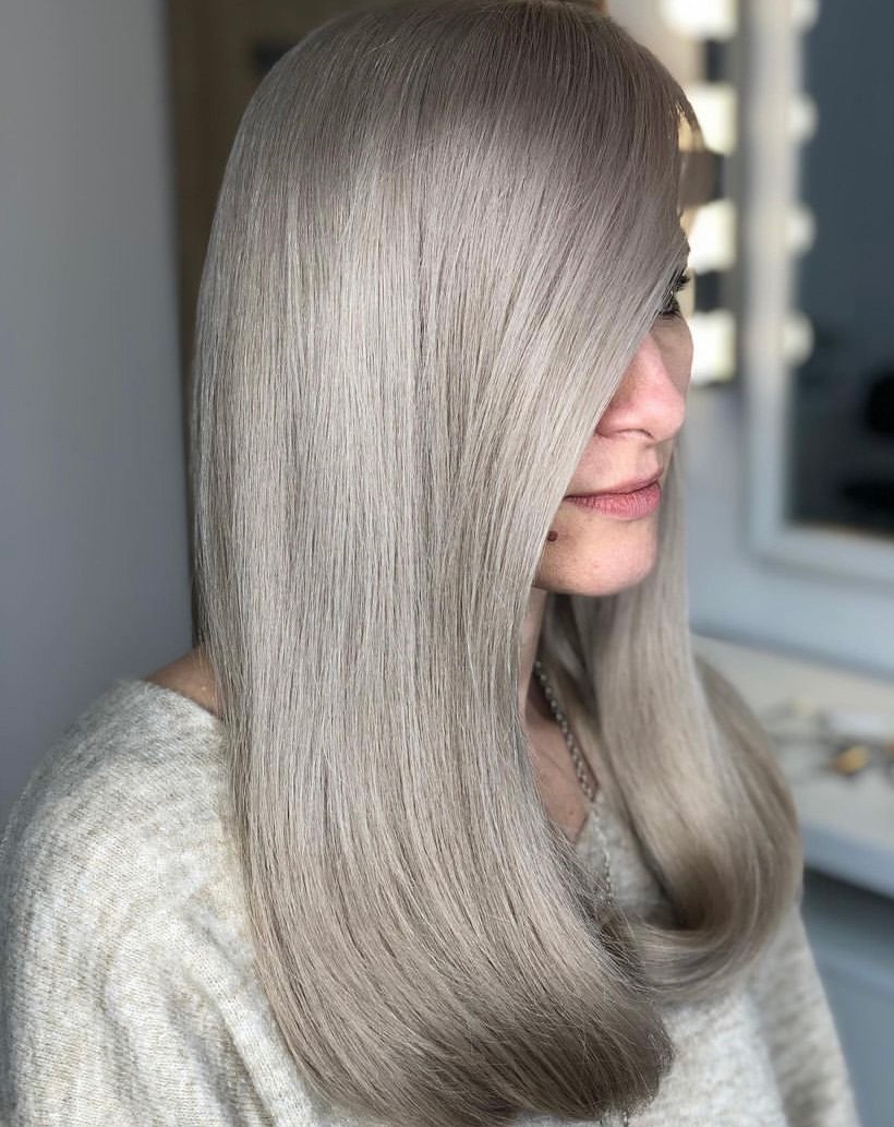 Mujer de cabello largo lacio con tinte color cenizo plata