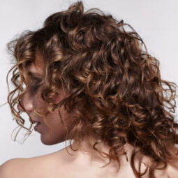 Mujer con corte para cabello rizado en capas cortas