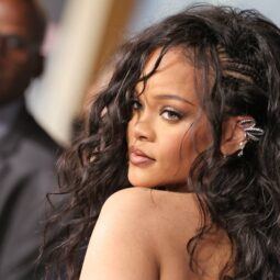Rihanna con peinado para frente grande, cabello rizado de lado con trenzas