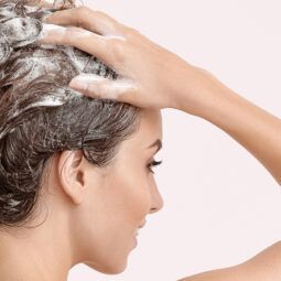 Mujer lavándose el cabello con shampoo purificante