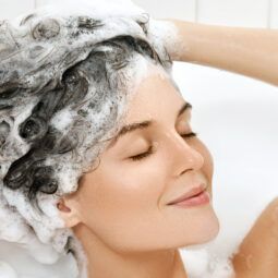 Mujer utilizando shampoo por higiene del cabello