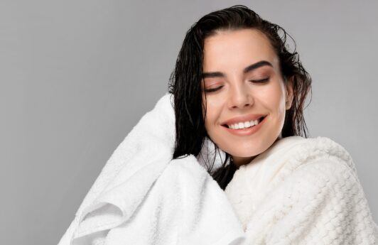Mujer saliendo de bañarse, secándose el cabello con una toalla