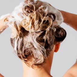 Mujer probando diferentes shampoos para la caída del cabello