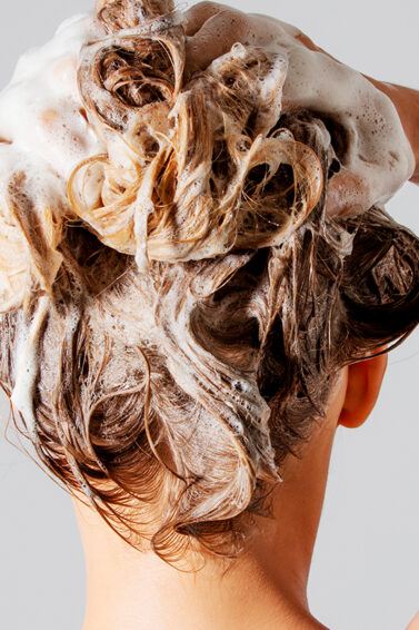 Mujer probando diferentes shampoos para la caída del cabello