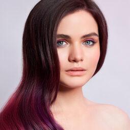 Mujer con puntas rojo violeta y cabello oscuro, ombré violeta
