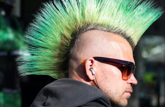 Hombre con corte mohicano punk y cabello verde