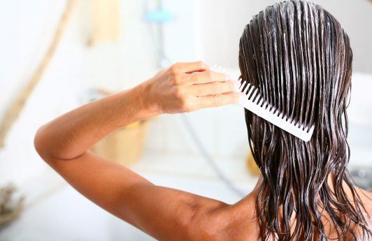 mulher lavando o cabelo com creme e penteando com pente