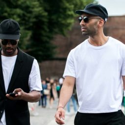 Dois homens usam bonés na rua