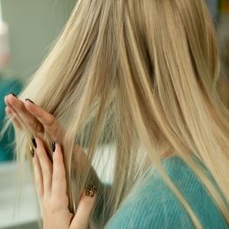 mulher passando a mão no cabelo loiro liso
