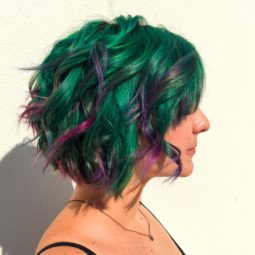 Mulher com cabelos verdes e mechas roxas