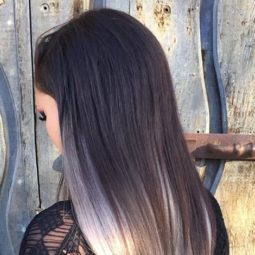 Mulher com cabelos platinados cinza e pontas loiras