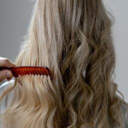 mulher penteando o cabelo loiro