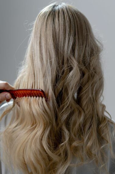 mulher penteando o cabelo loiro