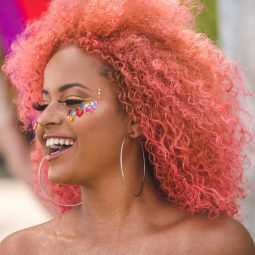 Mulher com cabelos cacheados cor de rosa no Carnaval