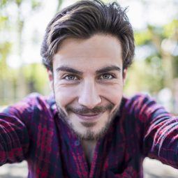 Homem com cabelos castanho-claros jogados para o lado em pose de selfie